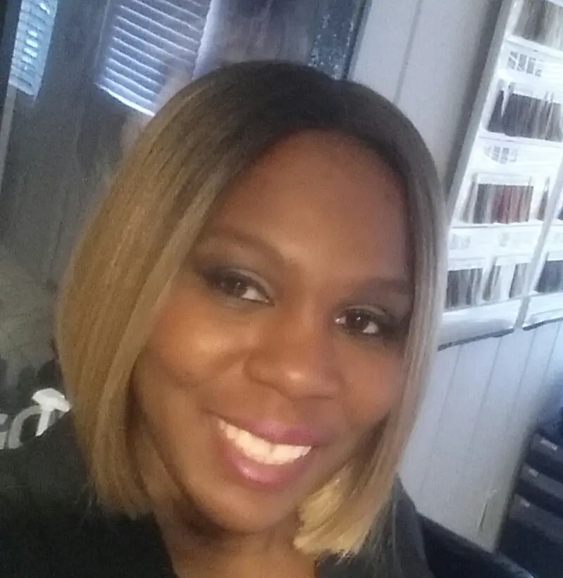 Smiling woman with blonde bob hairstyle.